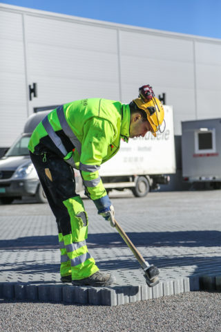 Adrian Mróz banker litt på steinene med en gummislegge for å få det helt nøyaktig. (Foto: Runar F. Daler).