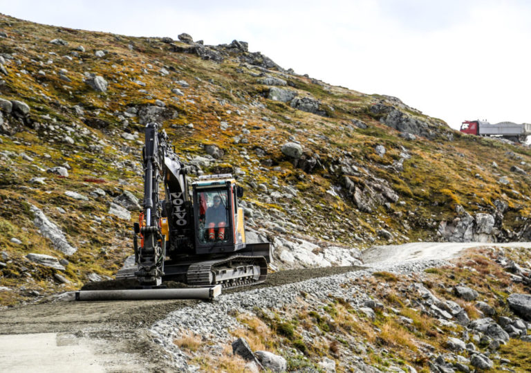 På vei opp den smale, svingete adkomstveien, ble vi møtt av en 15-tonns Volvo-graver med avretterbjelke, som var i ferd med å avrette og komprimere et nytt slitelag på veien. (Foto: Runar F. Daler).