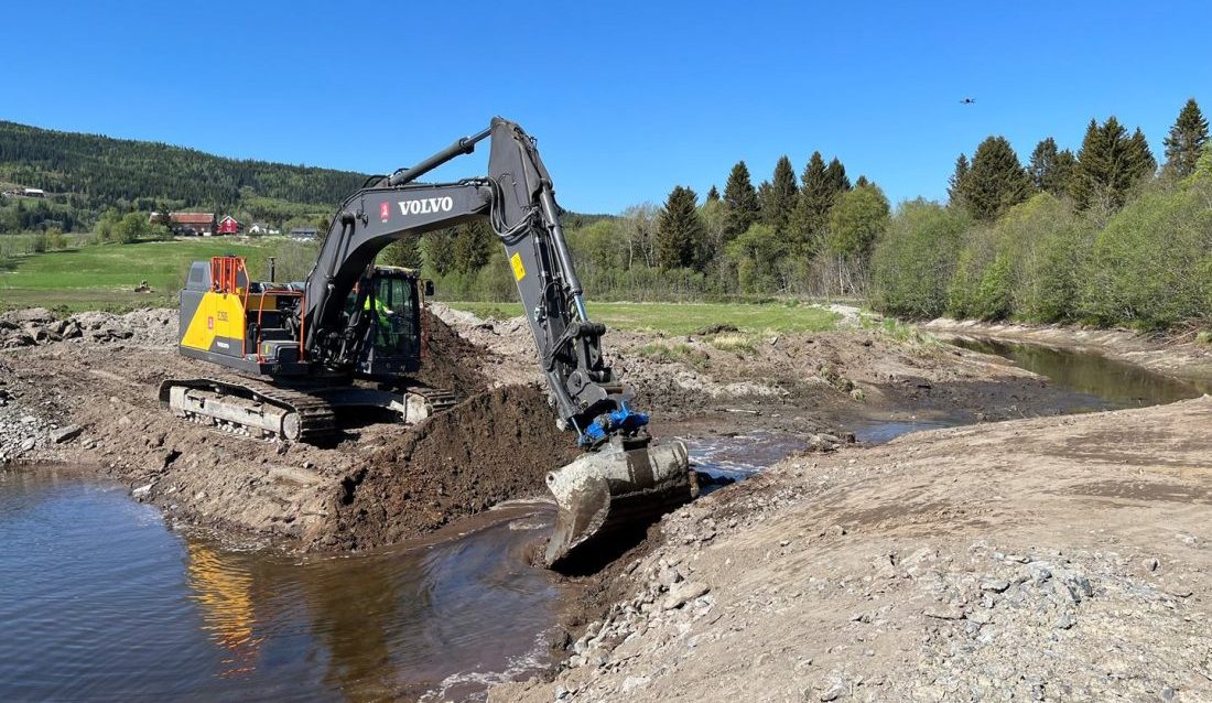 Volvo-graveren sørger for at vannet igjen kan renne fritt der det ikke har vært elv på 82 år. (Foto: NVE/Magne Fjeldheim)