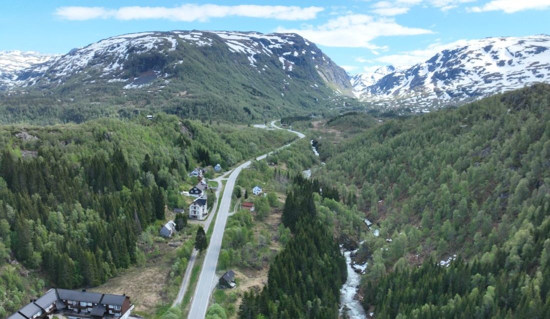 Dronebilde av fjellet ved Hesjabakkmyrane. Den nye Røldalstunnelen skal gå inn i fjellet til venstre. (Foto: Statens vegvesen)