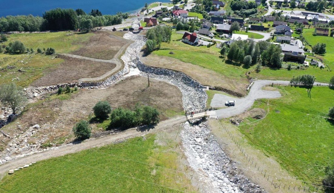 Ferdig erosjonssikring mot flom i Årsetelva i Jølster. Flommen i juli 2019 forårsaket store skader på bygninger og infrastruktur langs Årsetelva på Vassenden. Det ble iverksatt krisetiltak umiddelbart. (Foto: NVE Dronebilde)