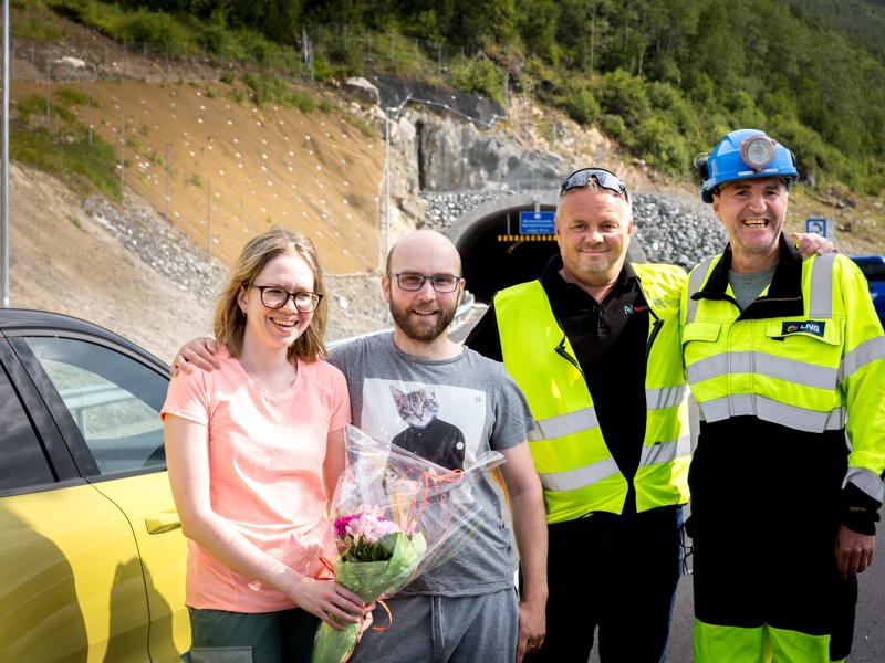 Hanne Merethe og Hans Albert Halden fra Nordreisa var de første som fikk kjøre gjennom den 2,5 kilometer lange Mettevolltunnelen på Kvænangsfjellet, onsdag. Paret, som var på vei til hytta i Kvænangen fikk blomster fra Geir Idar Foshaug fra Nye Veier, og Tore Danielsen fra LNS. (Foto: Nye Veier)