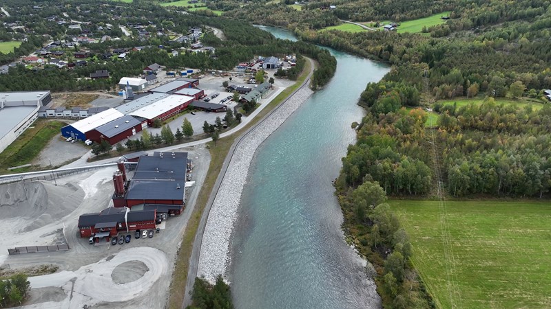 Industriområdet i Bismo ligger tett på den nye flomvollen. (Foto: NVE)