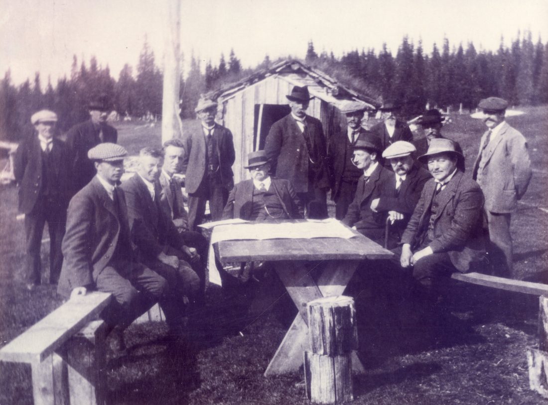 Fra åpningen av Innlandsvegen (rv.50 Grong-Mosjøen) 6. august 1924. Rund bordet sitter f.v.: J. Funder, Sjef Helgeland veiavdeling, F. Lyng, avd. ing. Vegdirektoratet, P. Ravlo, disp. Fylkesbilane Steinkjer, H.B. Guldahl, fylkesmann Nord-Trøndelag, A. Korsbrekke, overingeniør N Trøndelag, E. Clausen, amtsveterinær, O.T. Olsen, politimester i Helgeland. Stående f.v.: W. Paulsen, (sønn av E Paulsen) N. Mjåvatn, ordfører i Vefsn, E. Paulsen, Skyssstasjon Fellingfors, O. Tustervatn, ordfører i Hattfjelldal, B. Laksfors, Skysstasjon Laksfors, A. Skoksås, lærer og poståpner Grane, , L. Moe,gårdbruker Vefsn, ukjent.(Bilde: Ukjent fotograf/ Norsk vegmuseum)