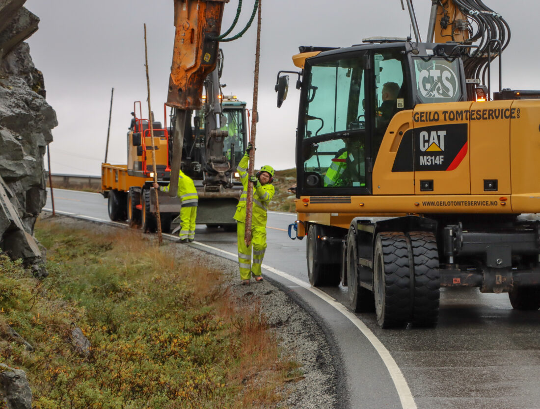 Arbeidslaget består av fem menn som har hver sin oppgave – pigge, sette ned brøytestikka, frakte sand, fylle sand i hullet rundt brøytestikka og sette på reflekstape. (Foto: Njål Hagen)