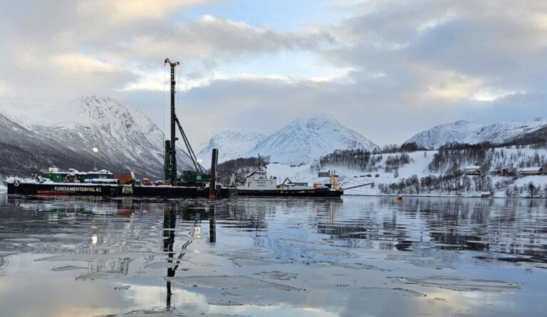 Arbeidet med å banke ned stålpelene som skal bære Ramfjordbroa er ferdig. Fra åsen midt i bildet, skal broa gå ned til sjøfyllinga på andre siden av fjorden. (Foto: Elisabeth Gundersen/Statens vegvesen)
