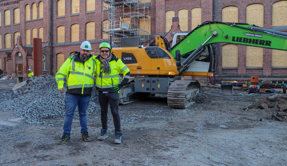 Stephan Karlsen (t.h.), prosjekt- og anleggsleder hos U.Reist, og Magnus Andreassen, salgsansvarlig hos Rental Group, foran den kabelelektriske Liebherr-graveren som er én av flere utslippsfrie maskiner på prosjektet med å rehabilitere Lilleborg skole. (Foto: Njål Hagen)