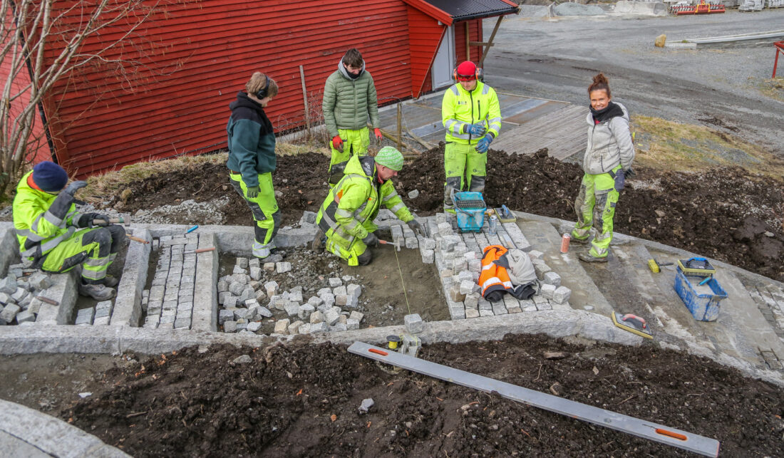 Vg2-elevene er i ferd med å etablere en fin uteplass med skiferheller, og mure opp en trapp med brostein og kantstein. (Foto: Runar F. Daler)
