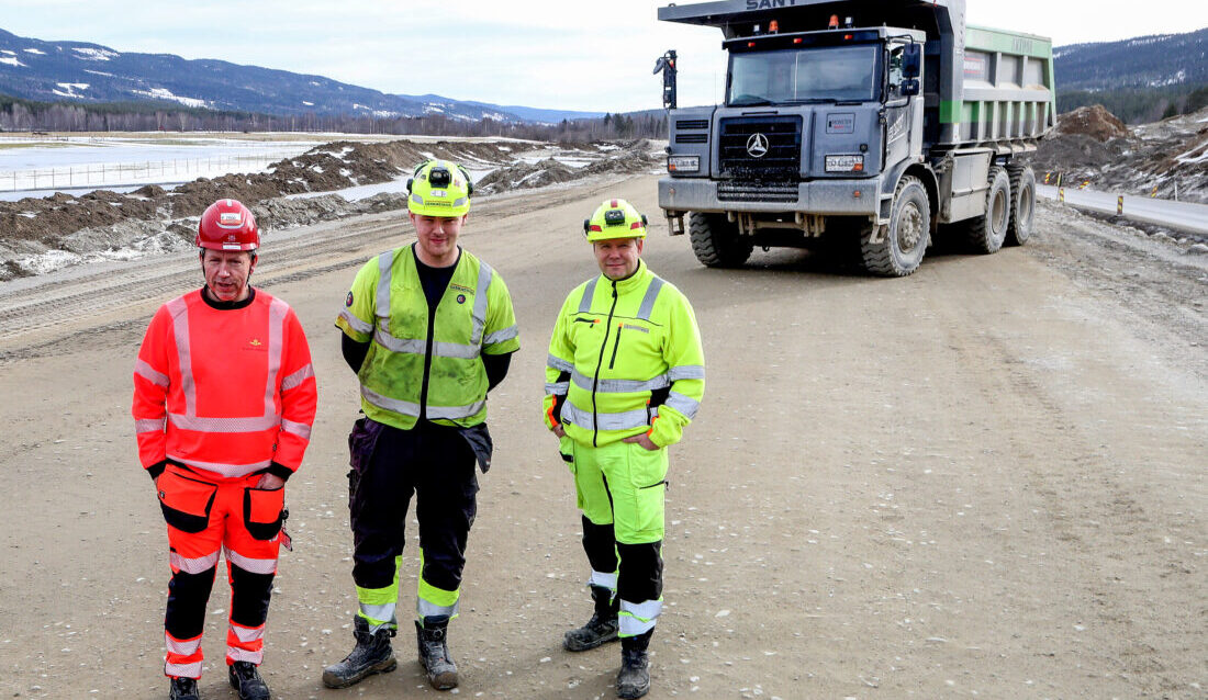 Denne elektriske tipptrucken blir testet på anlegget som krever svært mye masseforflytting. F.v.: Byggeleder Stig Johansen i Statens vegvesen, maskinfører i tipptrucken Lars Erik Nikolaisen Amundsen og anleggsleder Frank Mellemstuen i Anlegg Øst Entreprenør. (Foto: Harald Vingelsgaard)