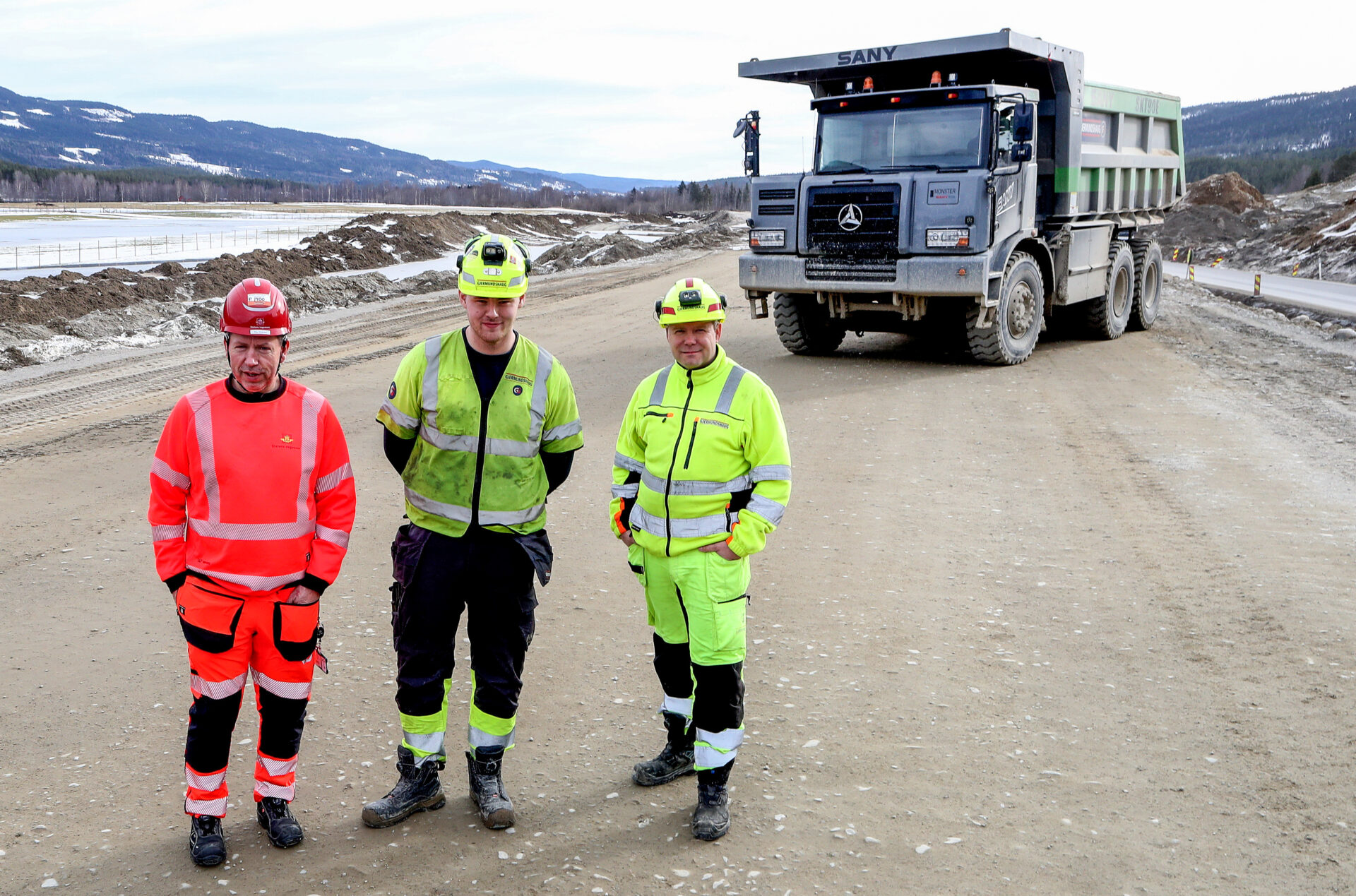 Denne elektriske tipptrucken blir testet på anlegget som krever svært mye masseforflytting. F.v.: Byggeleder Stig Johansen i Statens vegvesen, maskinfører i tipptrucken Lars Erik Nikolaisen Amundsen og anleggsleder Frank Mellemstuen i Anlegg Øst Entreprenør. (Foto: Harald Vingelsgaard)