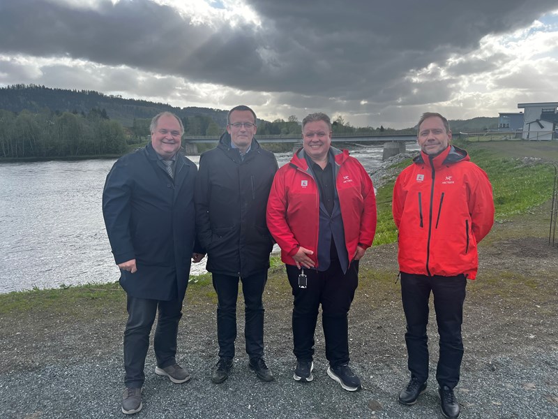 Ordfører Knut Snorre Sandnes, kommunedirektør Geir Olav Jensen, skred- og vassdragsdirektør Brigt Samdal og regionsjef Terje Thuseth på den nye flomvollen. (Foto: NVE)