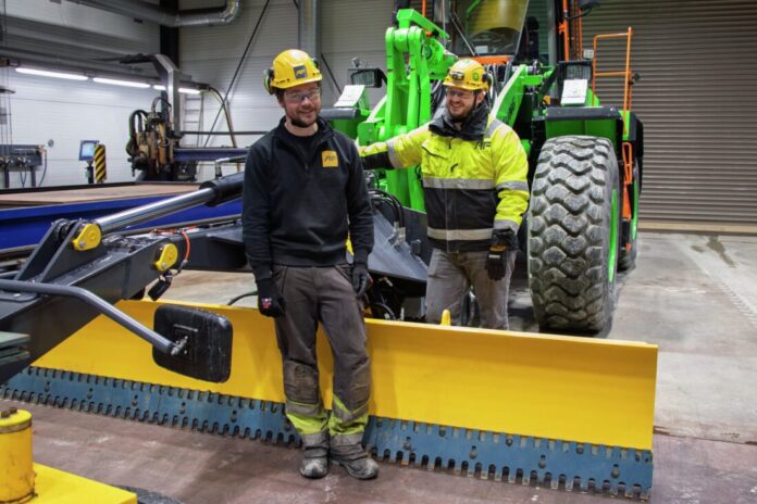 I AF Maskins store sveisehall på Haga i Akershus er prototypen montert på en elektrisk hjullaster av merket LiuGong. Olaf Kuskemoen og Jon Lunderby har tro på høvelskjæret. (Foto: AF)|Høvelskjæret skal testes på et av prosjektene til JR Anlegg