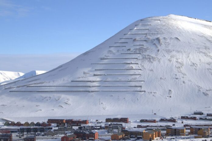 Langs fjellet Sukkertoppen ved Longyearbyen er det satt opp 2000 meter stive støtteforbygninger som hindrer snøras. (Foto: Arni Jonsson/Orion)