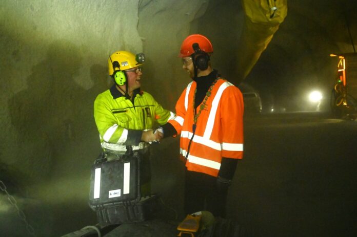 Kvitsøy-ordfører Kjell André Nordbø blir gratulert av bergsprenger Christian Solheim fra Implenia/Stangeland etter at den første salven var skutt og landets mest kompliserte tunnelprosjekt er i gang. (Foto: Øyvind Ellingsen/Statens vegvesen)|Med 250 arbeidere i sving på det meste