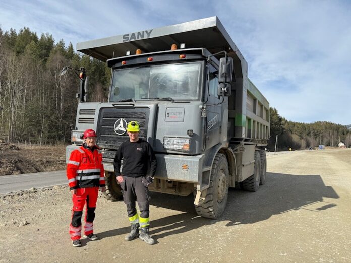 Prosjektleder Jan Egil Eilertsen fra Statens vegvesen og tipptrucksjåfør Lars Erik Nikolaysen Amundsen fra Anlegg Øst Entreprenør. De kinesiske tipptruckene har halve kapasiteten sammenlignet med dieseldrevne. (Foto: Linda Elisabeth Brateng/Statens vegvesen)|Feiret det gode samarbeidet med lunsj i vårsola: Fra venstre