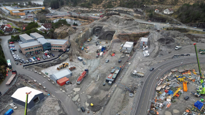 default Dronefoto som viser Knarreviktunnelen ved forskjæringen på Valaskiftet (omtrent midt i bildet). I bakgrunnen ser vi dagens riksvei 555, og til venstre Sotra Links kontorer. (Foto: Statens vegvesen)