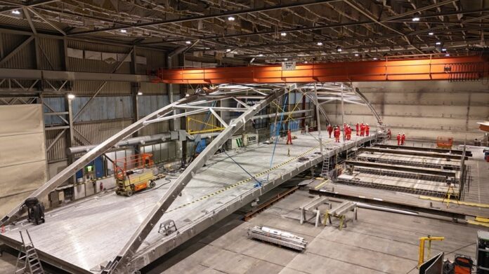 Hangarbroa består av fire deler som klaffer perfekt. Her er hele broa prøvemontert hos Leirvik AS. (Foto: Vegard Thorvaldsen/Statens vegvesen)|Cato Dørum og Geir Mosaker er svært fornøyde med resultatene fra prøvemonteringen av Hangarbroa. (Foto: Linda Grønstad/Statens vegvesen)|Prøvemonteringen gjør det mulig å sjekke at alle delene klaffer perfekt sammen før de skal sendes til Trondheim. (Foto: Linda Grønstad/Statens vegvesen)|Geir Mosaker (prosjektleder
