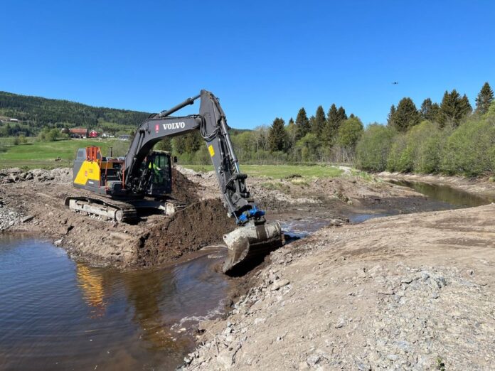 Volvo-graveren sørger for at vannet igjen kan renne fritt der det ikke har vært elv på 82 år. (Foto: NVE/Magne Fjeldheim)|F.v.: Terje Thuseth