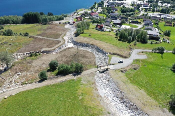 Ferdig erosjonssikring mot flom i Årsetelva i Jølster. Flommen i juli 2019 forårsaket store skader på bygninger og infrastruktur langs Årsetelva på Vassenden. Det ble iverksatt krisetiltak umiddelbart. (Foto: NVE Dronebilde)