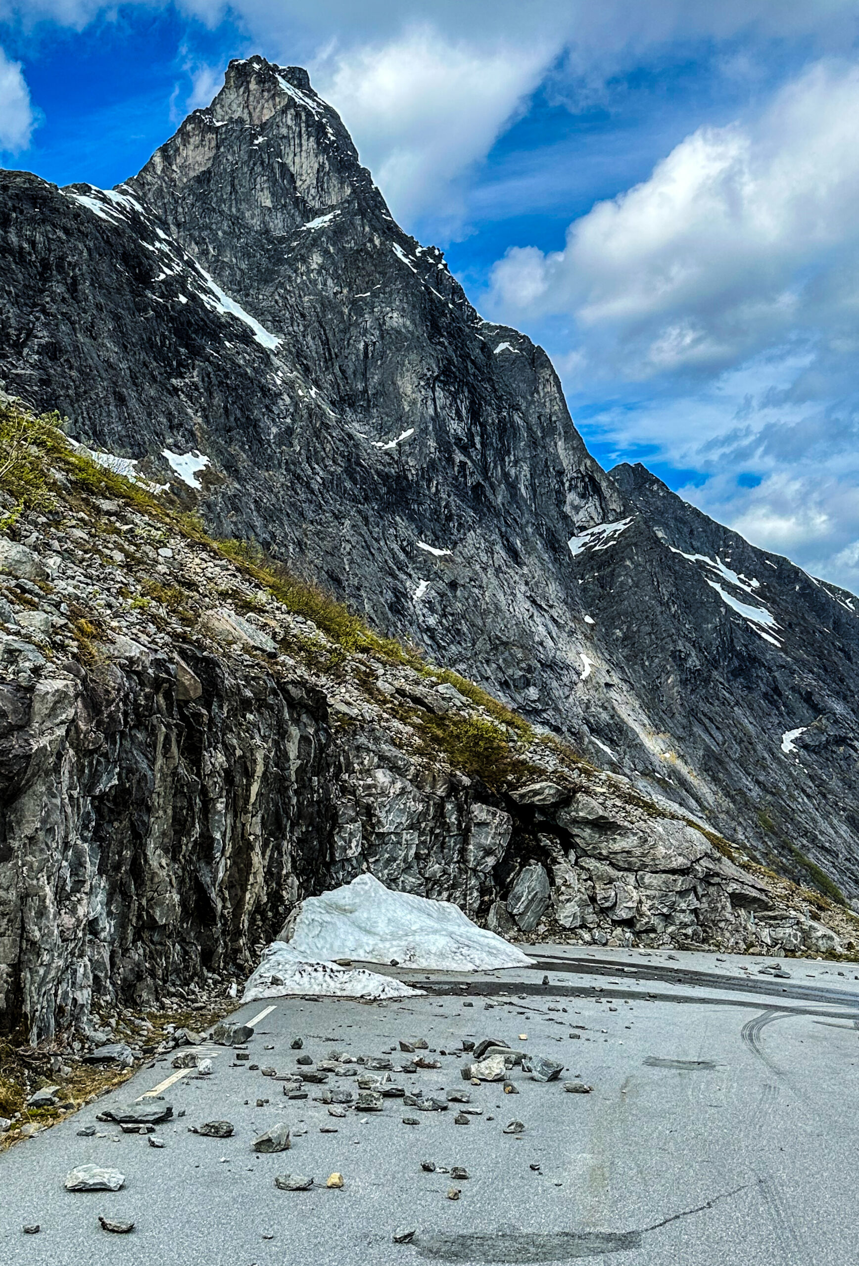 Den pågående fjellsikringen er et strakstiltak, med håp om å kunne åpne veien i juli i år. Samtidig kartlegges behovet for et fremtidig, mer komplett sikringstiltak for hele Trollstigen. Bildet, som er fra den andre siden av dalen fra der sikringen nå pågår, viser tydelig at det er behov for ytterligere sikring. (Foto: Runar F. Daler)