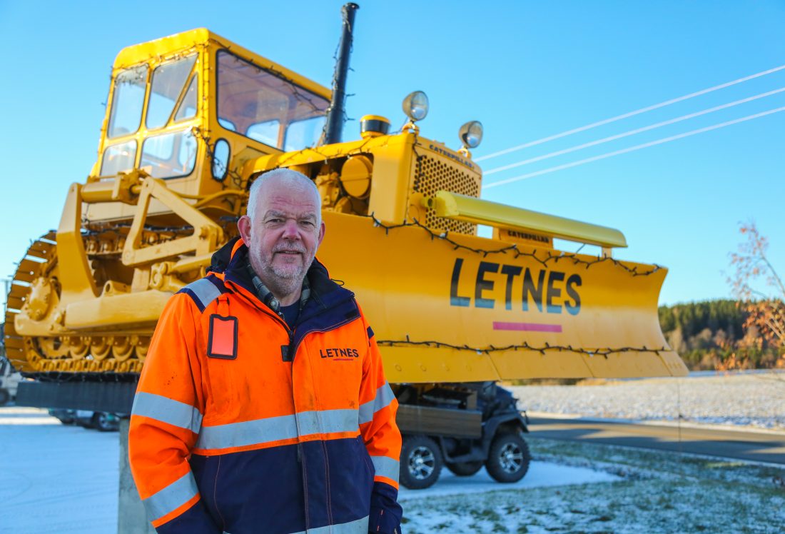 Letnes AS hadde sin spede begynnelse i 1961, da grunnlegger Anton Magne Letnes gikk til innkjøp av en splitter ny bulldoser av typen Caterpillar D-4. Daglig leder David Letnes, sønnen til grunnleggeren, står her foran maskinen det hele startet med. (Foto: Runar F. Daler)