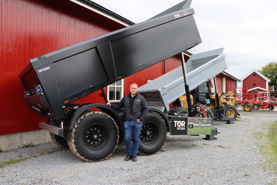 Ståle Rennemo, salgssjef hos Norwegian Trailer System, foran den svarte 15T50H-hengeren (15 tonn nyttelast og 50 km/t). I bakgrunnen står modellen 12T40. (Foto: Njål Hagen)