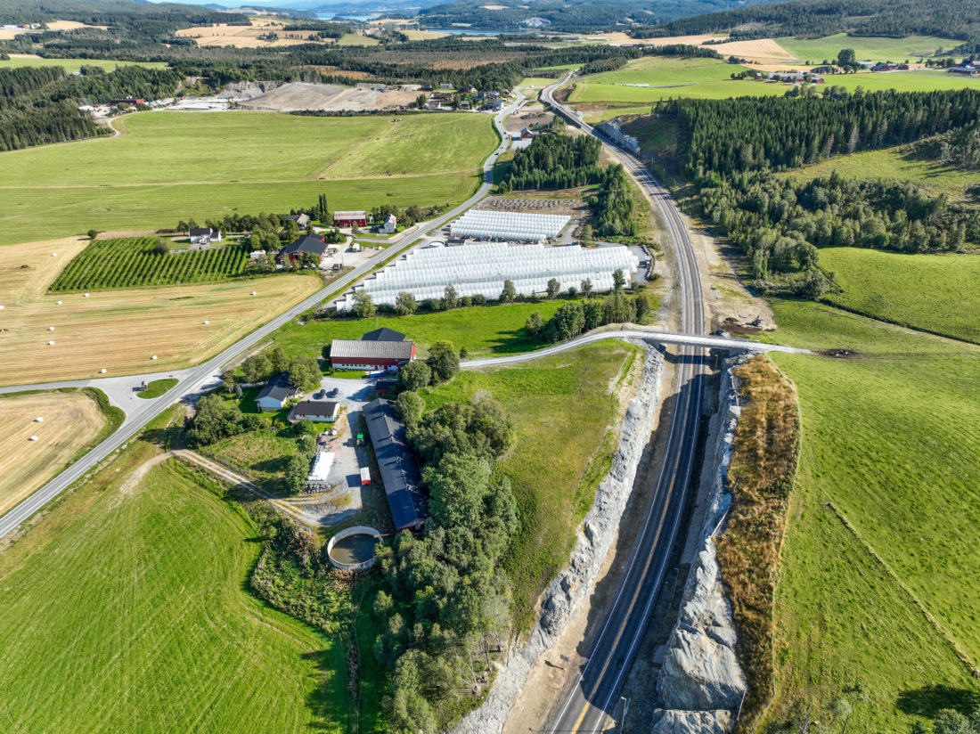 OVENFRA: Dronefoto like før åpningen av veien. Her kan man blant annet se en fjellskjæring, samt litt av den nye lokalveien på nordsiden av fylkesveien. (Foto: KNE-Røstad ANS)
