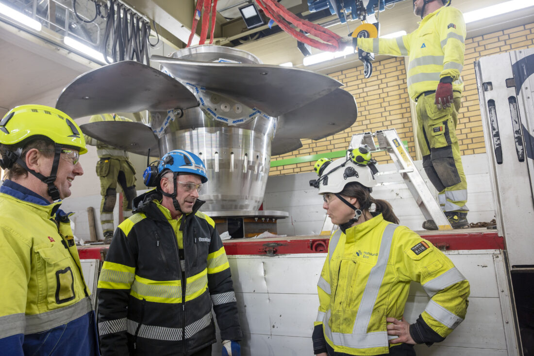 Kristian Glemmestad i Andritz Hydro (t.v.), Finn Arne Sundbrei fra Sundbrei Transport og Hafslunds prosjektleder Kristin Vestmoen er fornøyde etter at den første elektriske transporten av deler til vannkraftindustrien er gjennomført. (Foto: Norsk Scania)