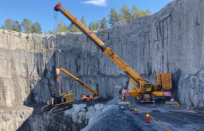 mobilkran løfter stor gravemaskin|Gravemaskin på lekter|tipptruck med stein