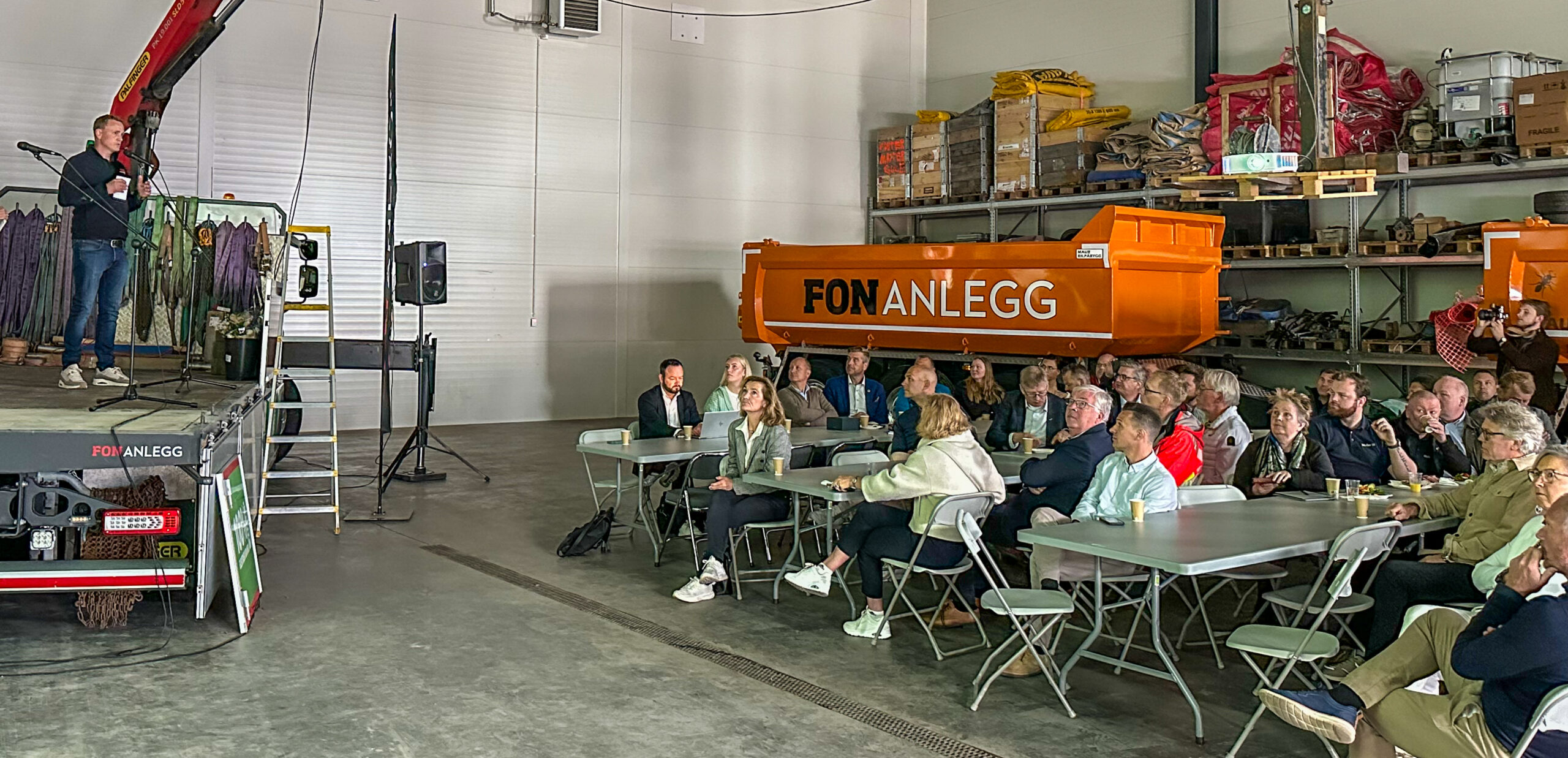 Daglig leder Joakim Aarøe fortalte om anlegget fra en provisorisk «scene» på den ene ev bedriftens to elektriske lastebiler. (Foto: Runar F. Daler)
