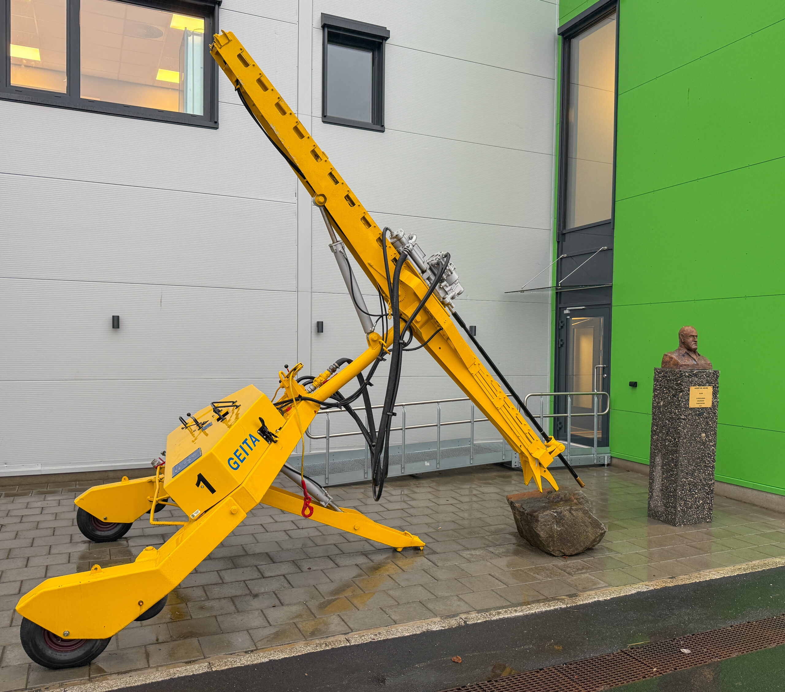 Utenfor inngangen står en byste av Albert Hæhre og hans første borerigg – Geita. (Foto: Njål Hagen)