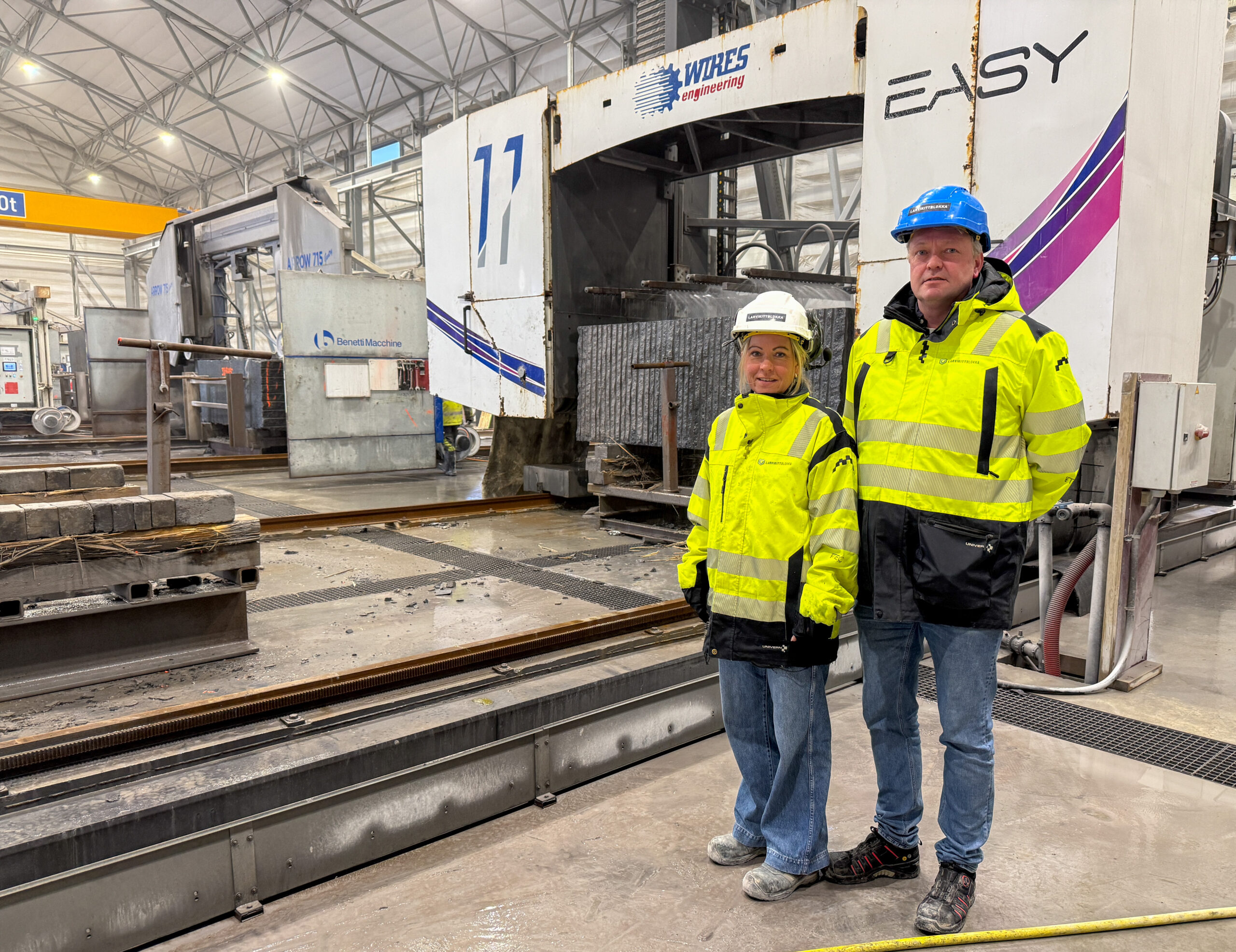 Hanne Støvland Jørgensen og Jan Henrik Hansen foran en av sagene som brukes for å produsere Larvikittblokka i forskjellige størrelser. (Foto: Njål Hagen)
