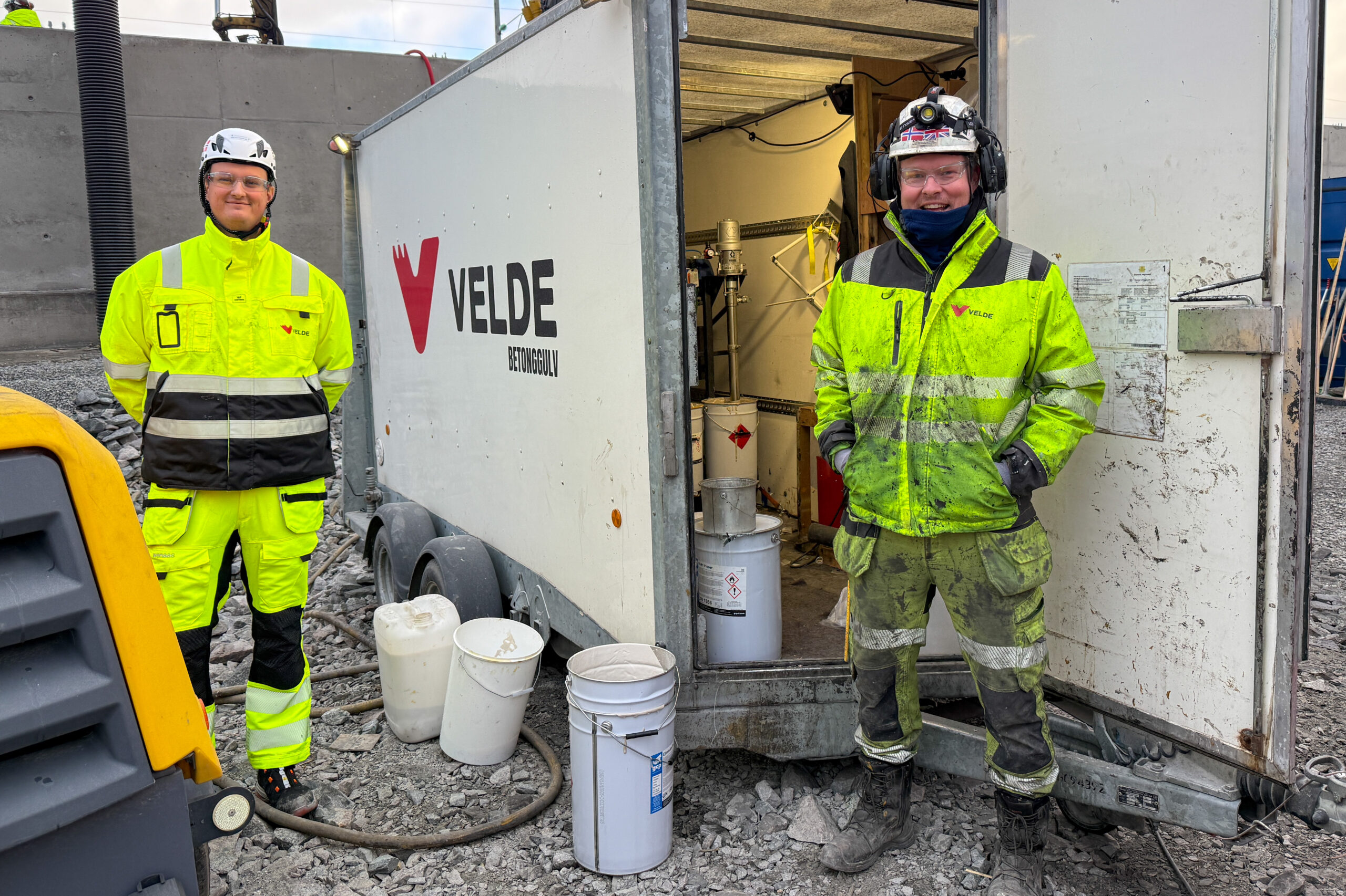 Harald Rosengren (t.v.), Velde Gulv, og David Stensland, Agder Entreprenør, ved tilhengeren som rommer alt av utstyret de bruker for å legge Eliminator. (Foto: Njål Hagen)