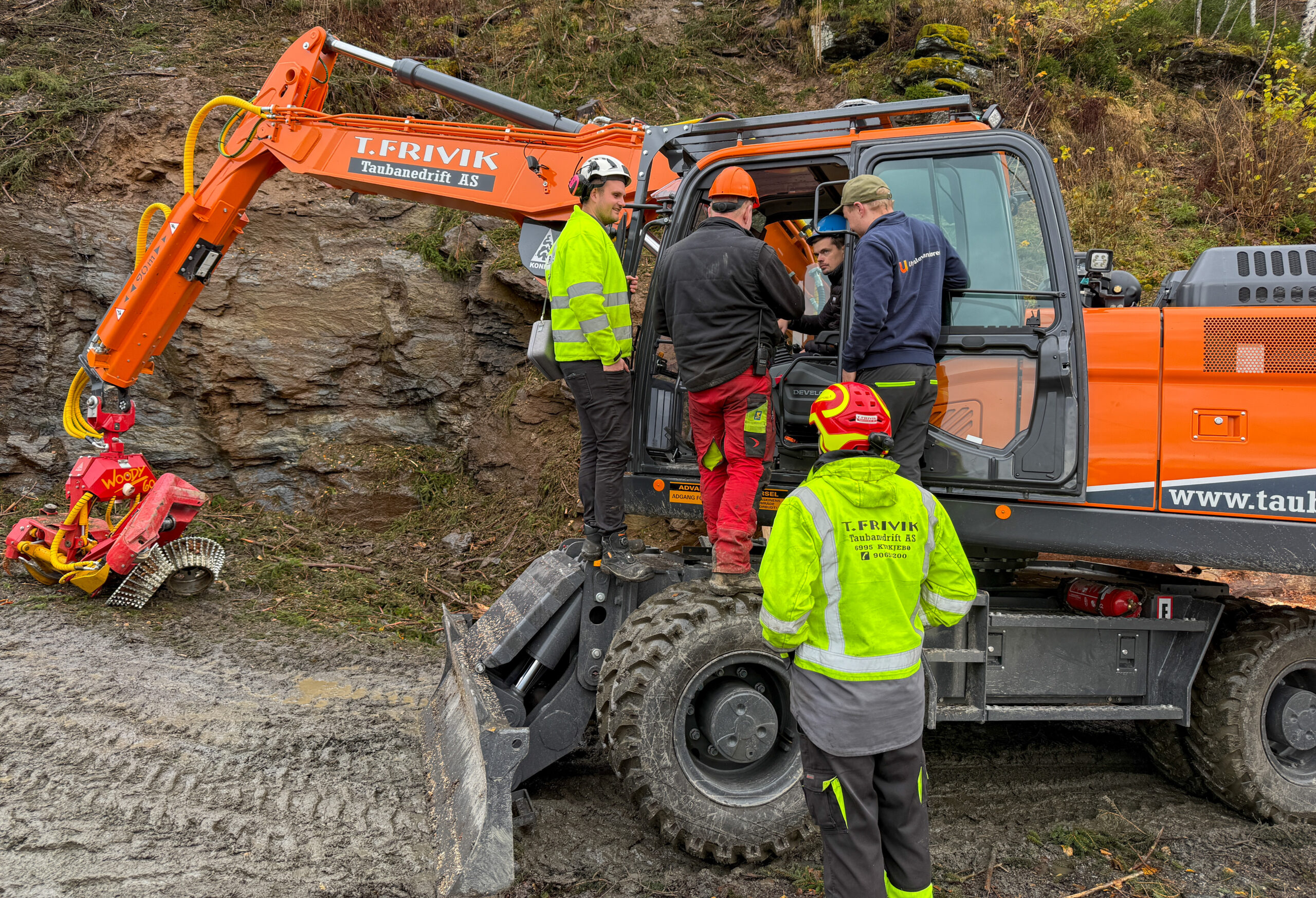 Hjulgraveren Develon DX210W-7 var den første av den nye serien som ble levert i Norge. Maskinen ble bygget om hos Konrad Forsttechnik GmbH i Østerrike før levering til T. Frivik Taubanedrift, og maskinfører Eugenius Klumbys hadde kun kjørt den noen få timer da vi var på besøk. Samme dag var Sverre Mjelstad (t.v.), selger hos Rosendal Maskin, Anders Buer Nordli (i maskinen), produktsjef hos Rosendal Maskin, og Jonatan Nygard fra Utstyrsleverandøren tilstede for å ha en gjennomgang på maskinen. (Foto: Njål Hagen)