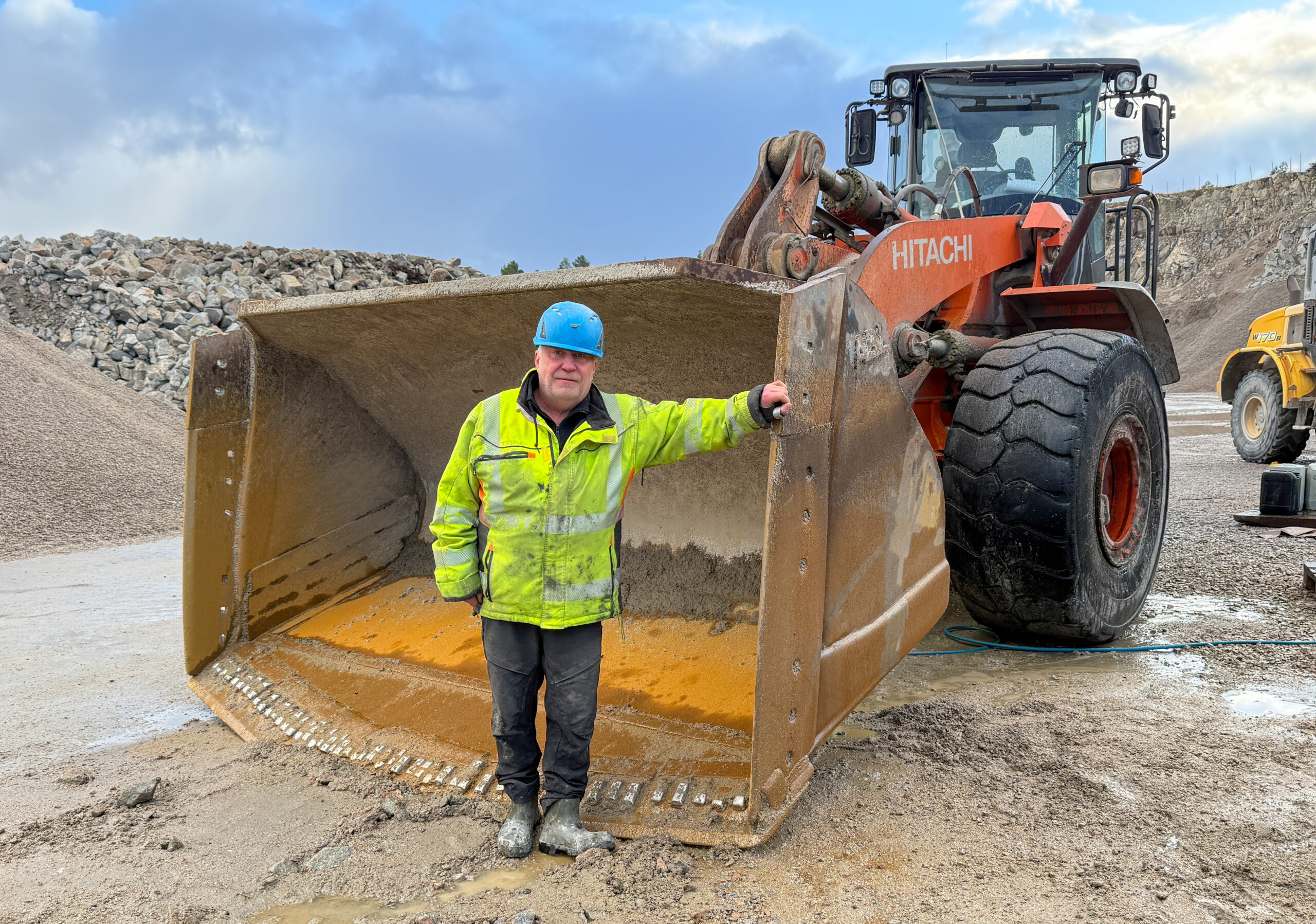 Ingvar Strømmen kom tilbake til Hitra Bergverk etter 40 år med å jobbe med laks. Han er selskapets «Petter Smart» og har bidratt med løsninger som effektiviserer driften. Hitachi-hjullasteren er elleve år gammel og har gått 17 300 timer. (Foto: Njål Hagen)