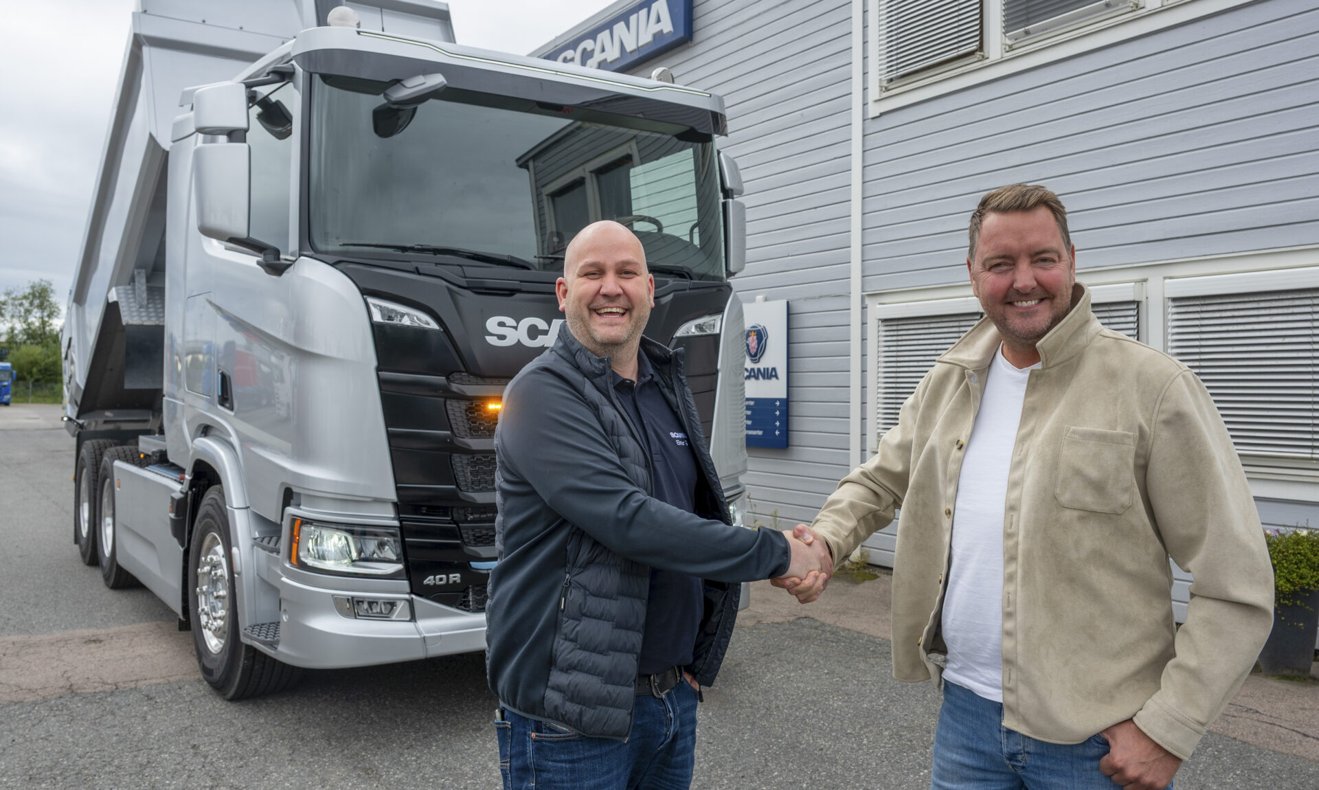 Scaniaselger Einar Gudegjerde (t.v.) og Bjørnar Pedersen, daglig leder i Bjørnars Transport «shake hands» etter bestillingen av 30 nye elektriske Scania. (Foto: Scania)