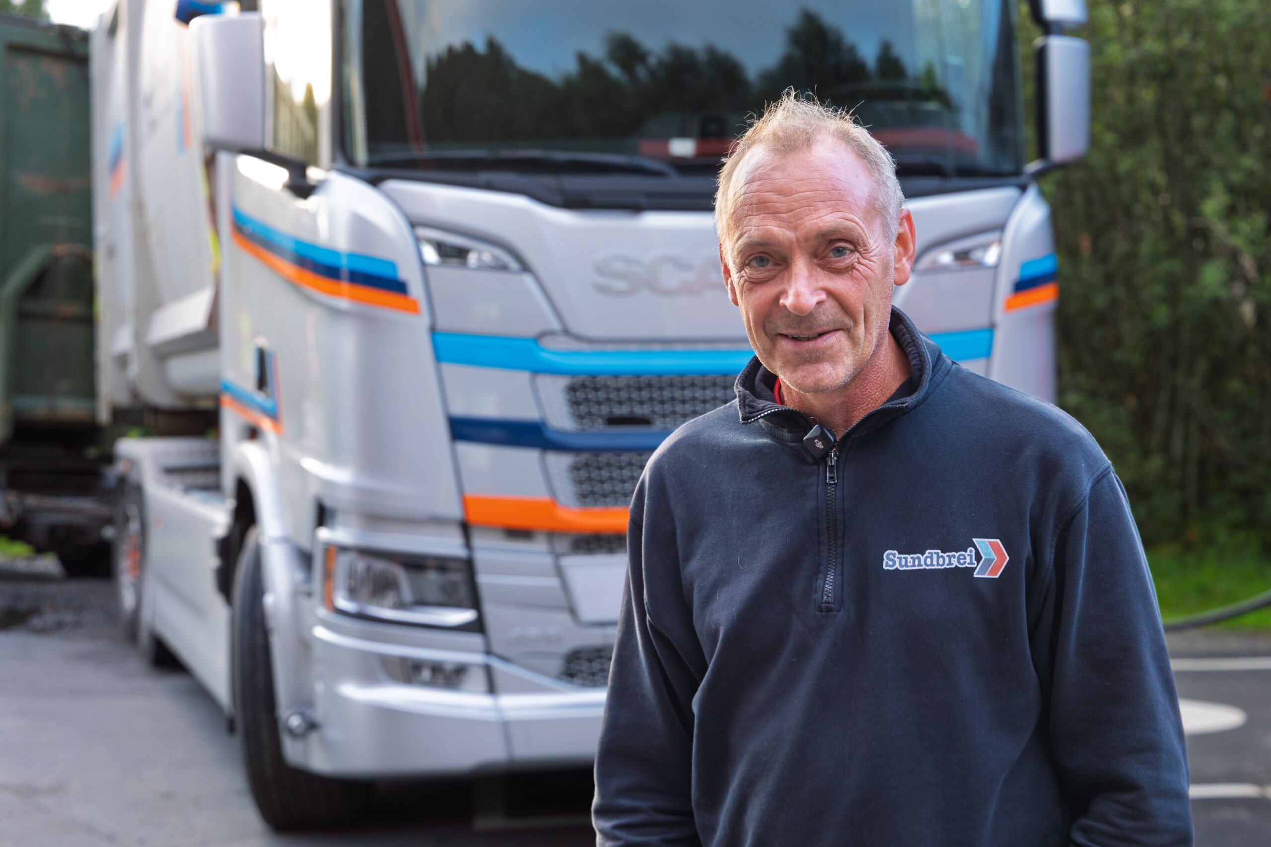 Finn Arne Sundbrei driver Sundbrei Transport sammen med sin far Per Egil. De har så lang to elektrisk lastebiler i tillegg til et tjuetalls diesellastebiler. I løpet av høsten får de ytterligere to elektriske. (Foto: Norsk Scania)